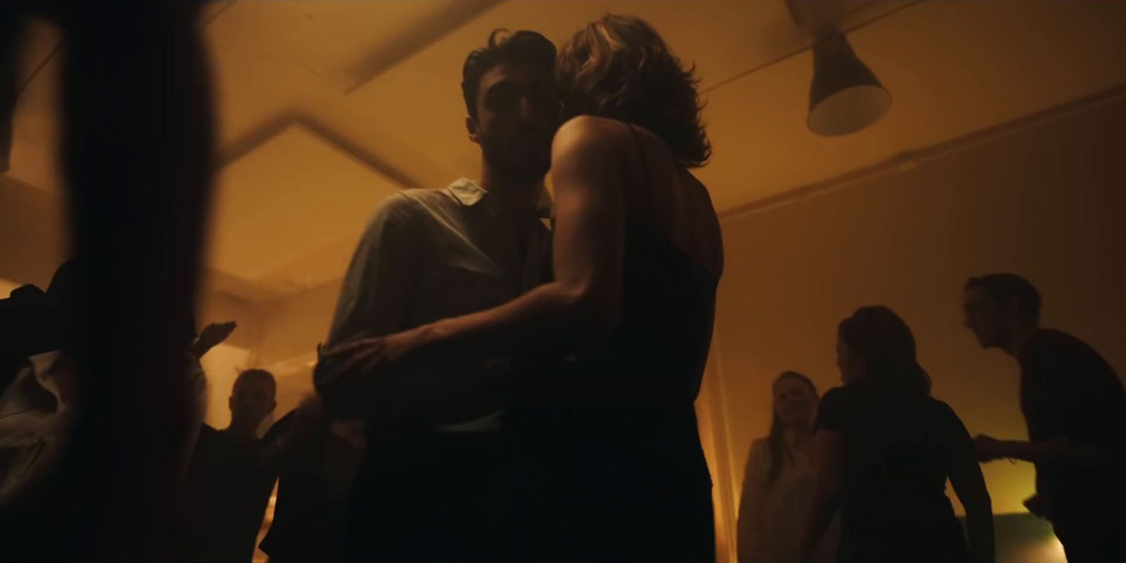 a man and woman dancing in a dimly lit room