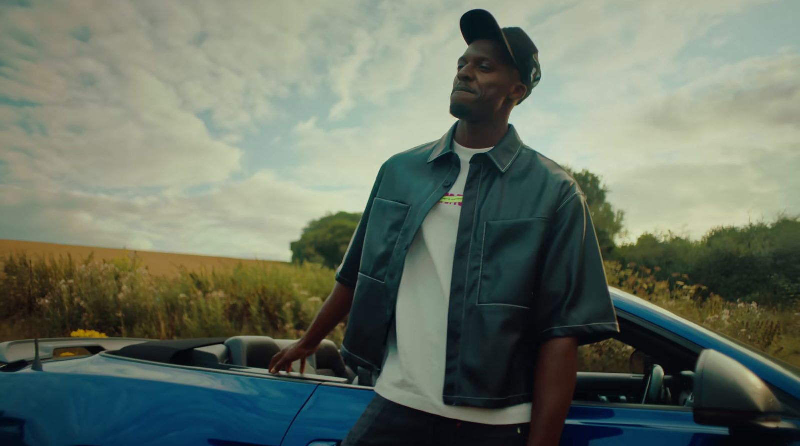 a man standing next to a blue sports car