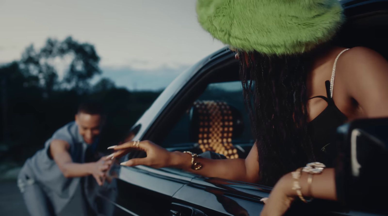 a man standing next to a woman in a car