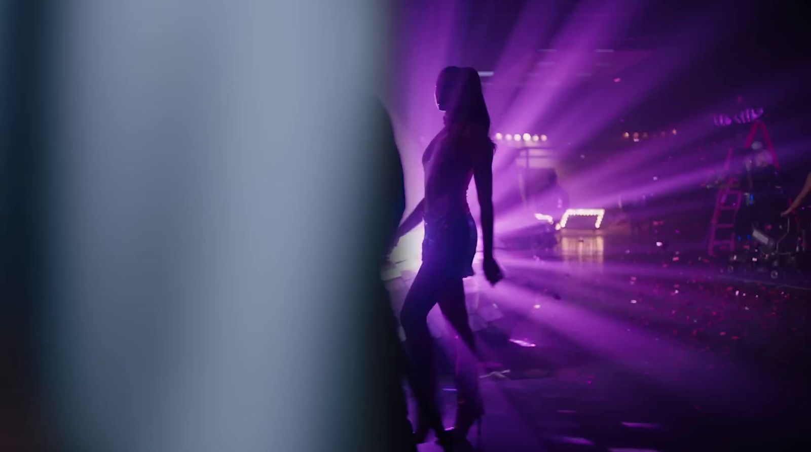 a woman standing in front of a purple light