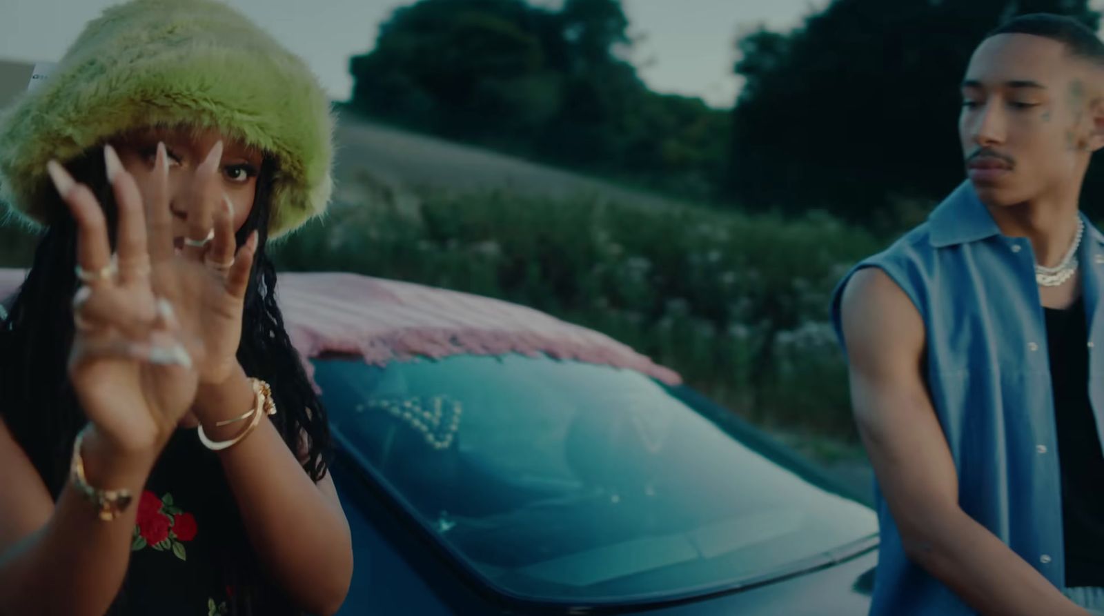 a man standing next to a woman in front of a car