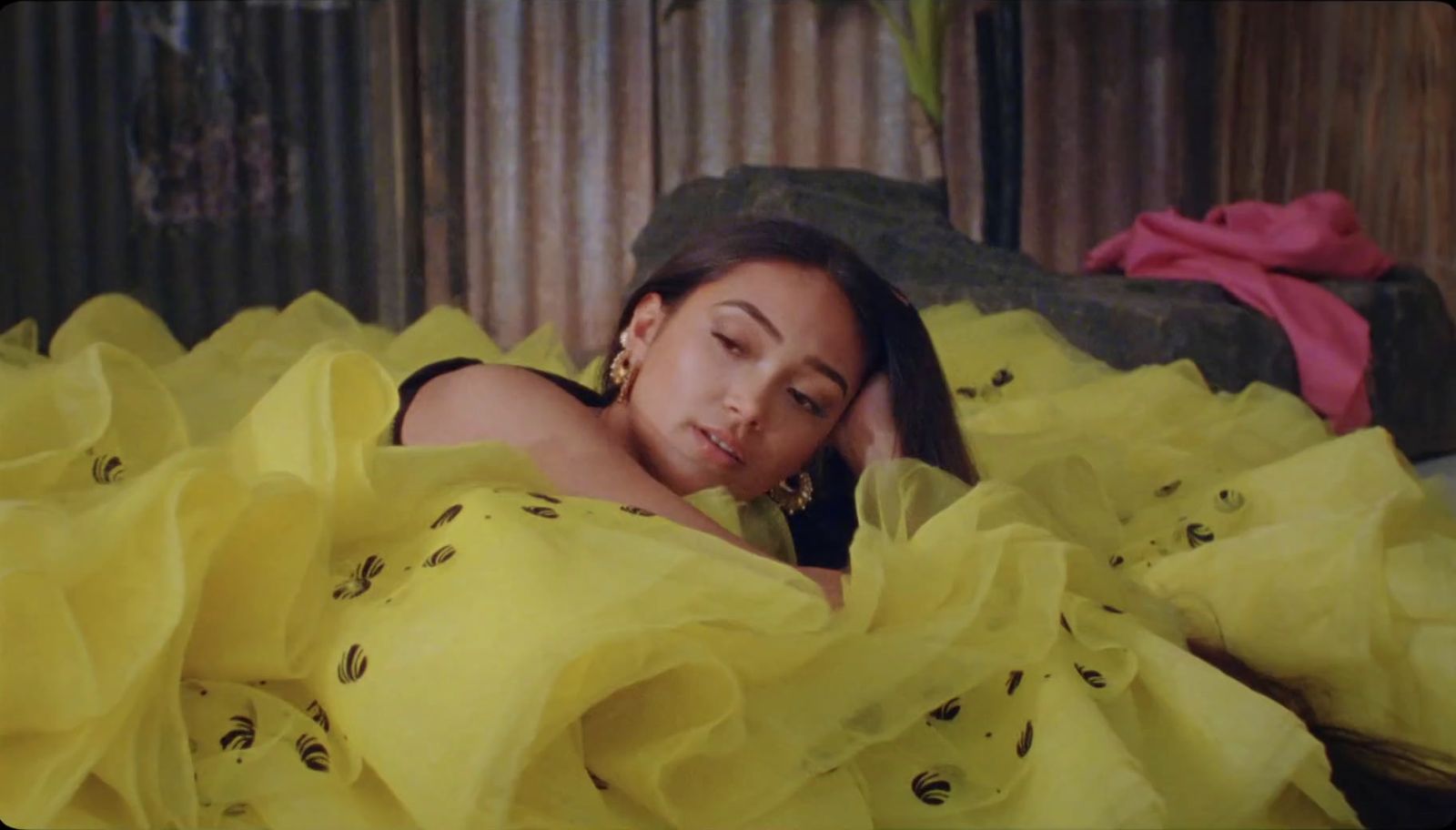 a woman laying in a bed covered in yellow sheets