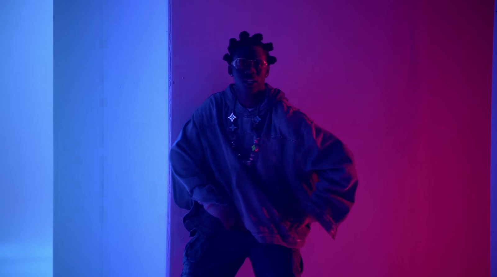 a man standing in front of a purple and blue wall