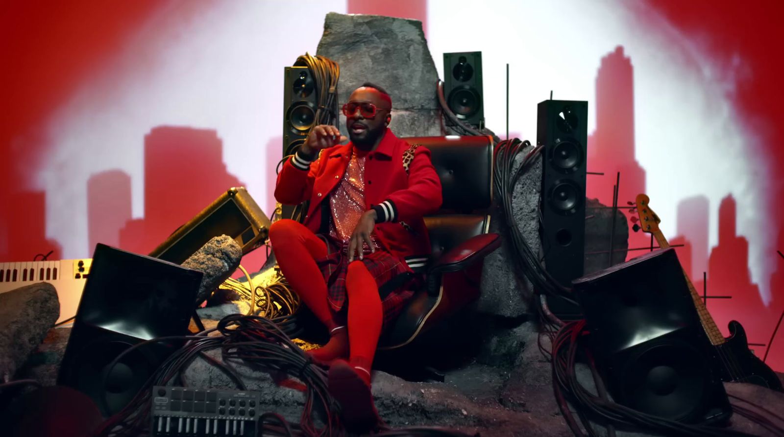 a man sitting in a chair surrounded by speakers