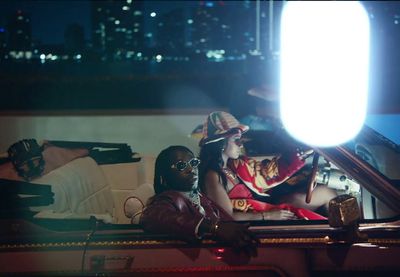 a group of people sitting around a car at night