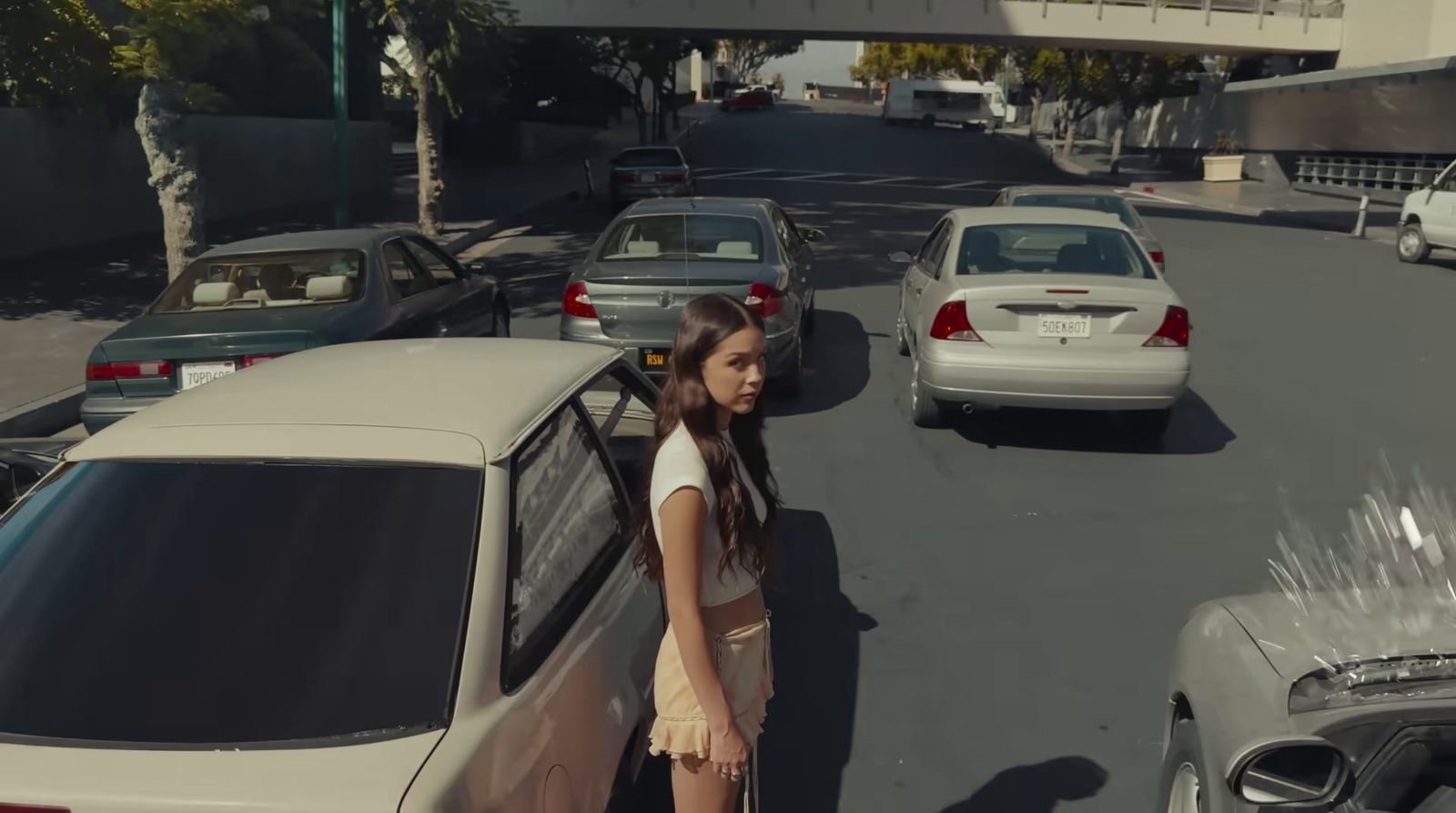 a woman standing next to a car on a street