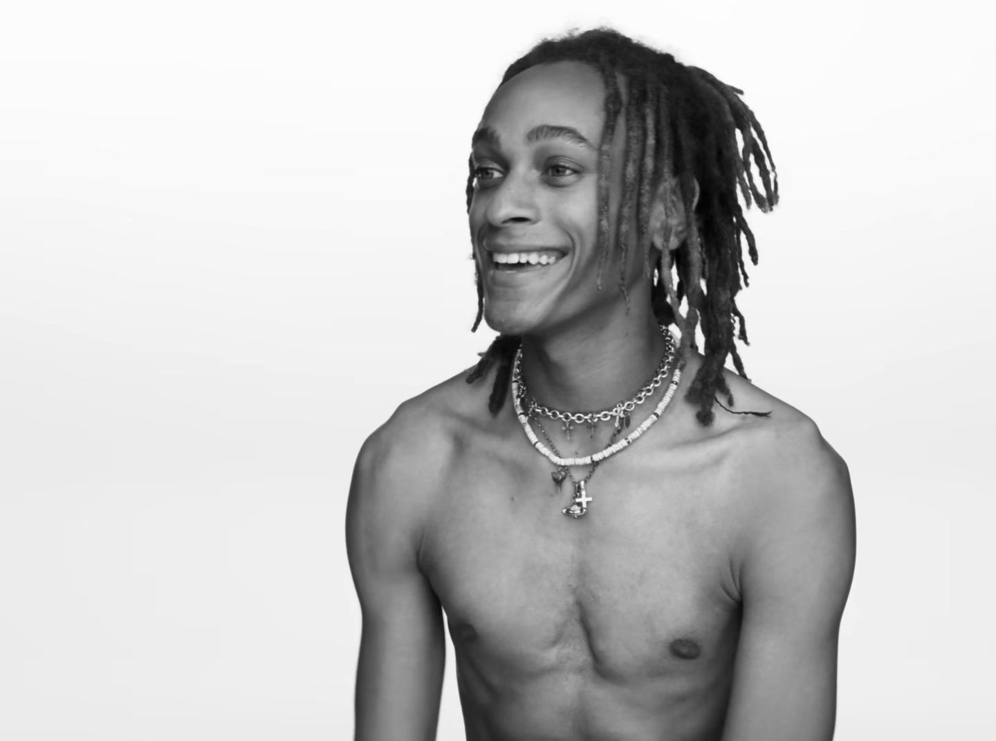 a black and white photo of a man with dreadlocks