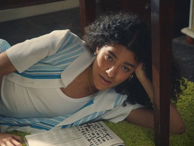 a woman laying on the ground reading a book