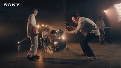 a group of men standing around a drum set