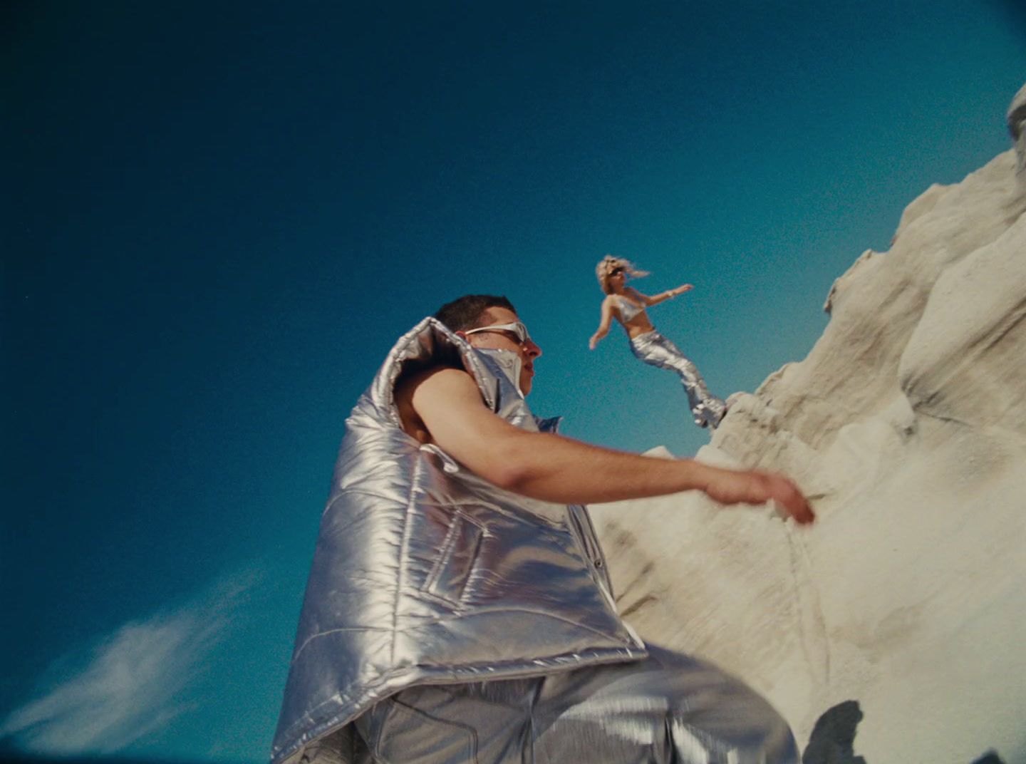 a man in a silver suit is holding a frisbee