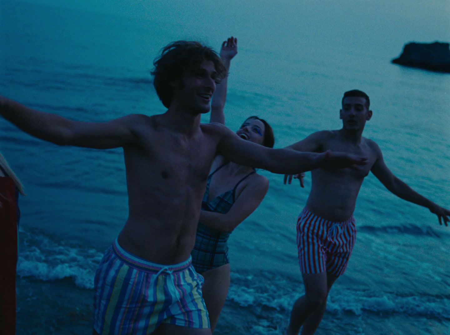 a couple of people standing on top of a beach