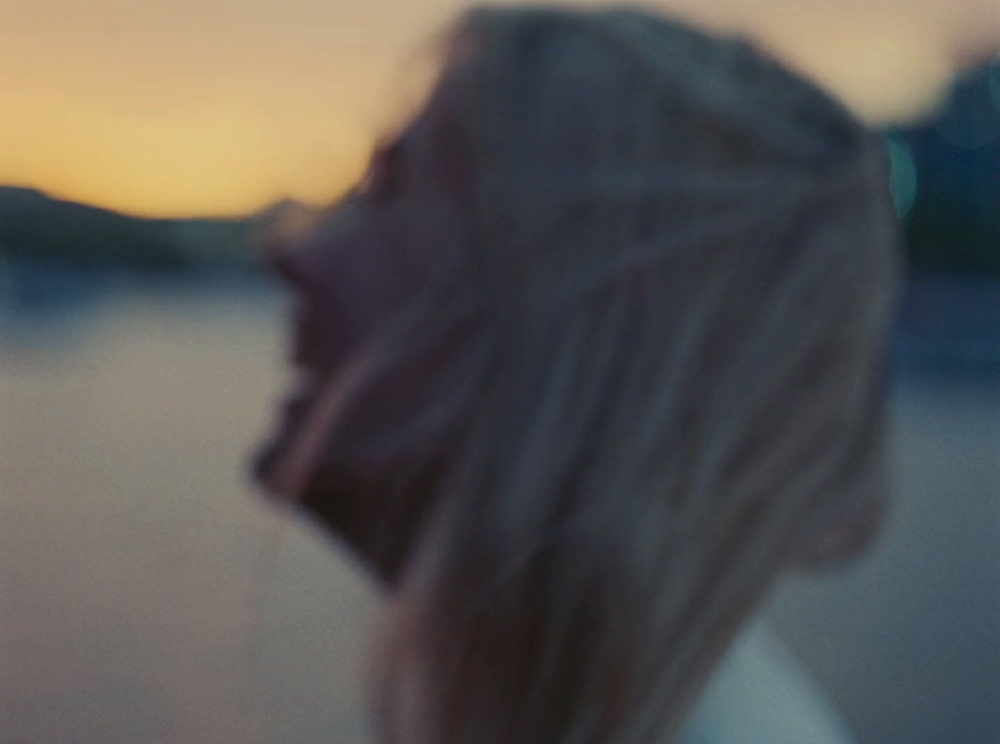 a blurry photo of a woman looking at the water