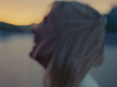 a blurry photo of a woman looking at the water