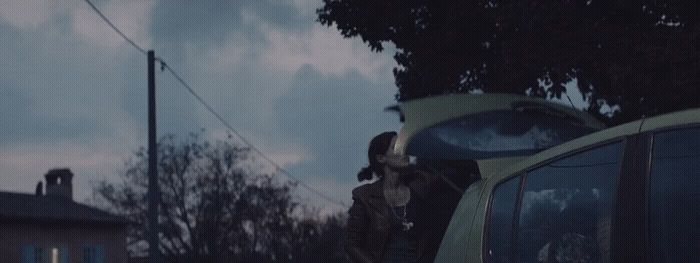 a man standing next to a car on a street