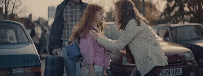 a man and a woman standing next to each other in a parking lot