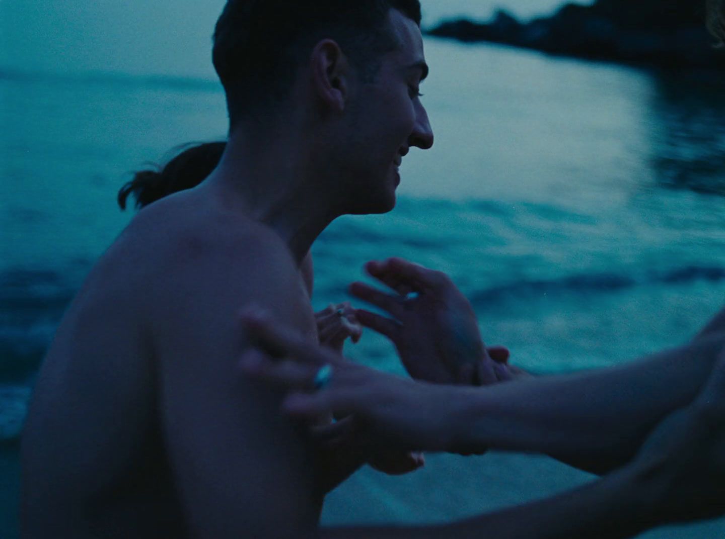 a man and a woman standing next to each other on a beach