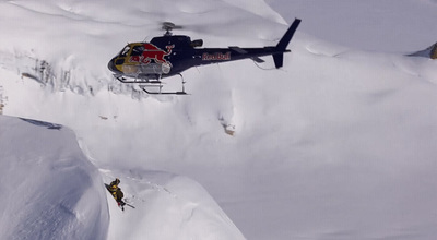 a helicopter flying over a snow covered mountain