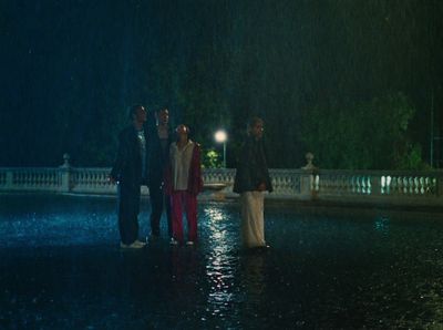 a group of people standing in the rain at night