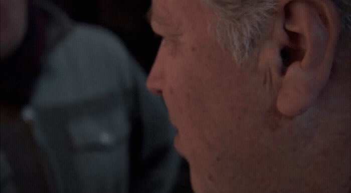 a close up of a person wearing a suit and tie