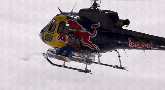 a red bull helicopter is flying through the air