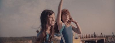 two women standing next to each other holding a frisbee