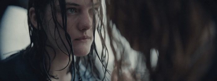 a woman with wet hair standing in front of a mirror