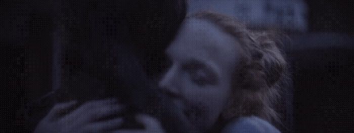 a woman is hugging a man in the dark