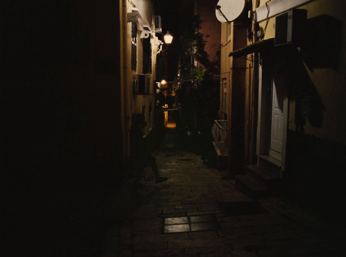 a dark alley with a clock on the wall