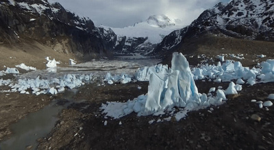 an aerial view of a glacier with mountains in the background