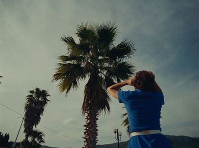 a man standing next to a palm tree