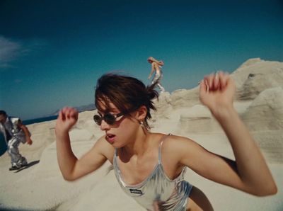 a woman in a tank top running on a beach