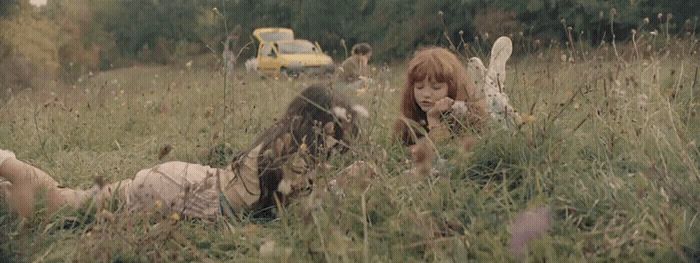 a woman laying on the ground in a field