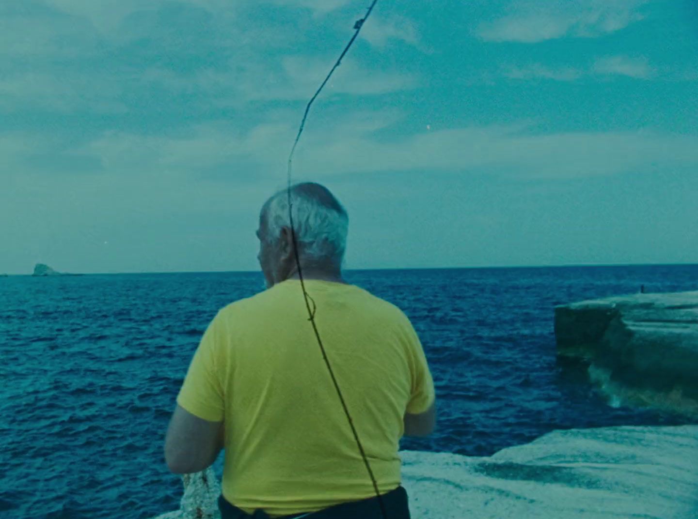 a man standing on top of a cliff next to the ocean