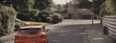 an orange car is parked on the side of the road