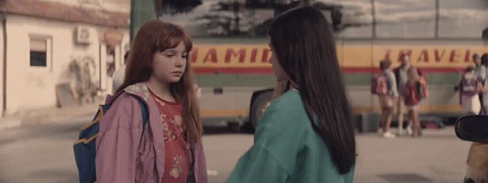 two young women standing in front of a bus