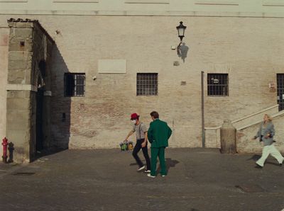 a group of people walking down a street next to a building