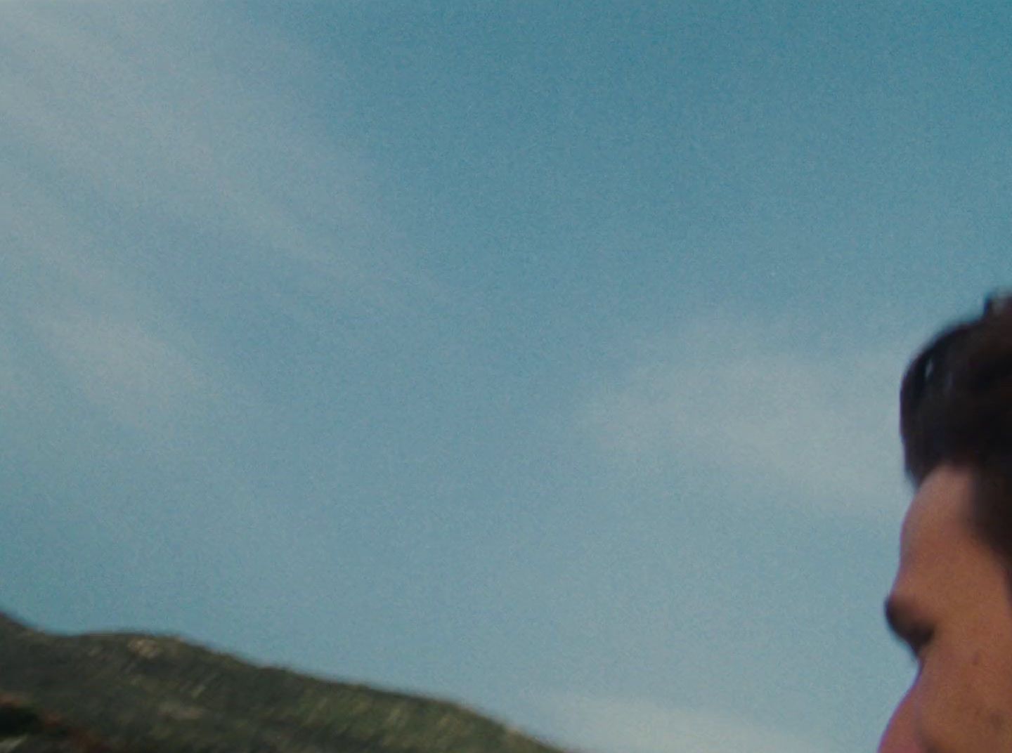 a man flying a kite in a blue sky