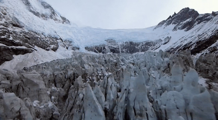 a large glacier with a mountain in the background