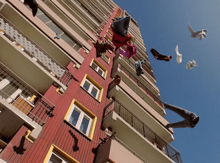 a group of birds flying around a tall building