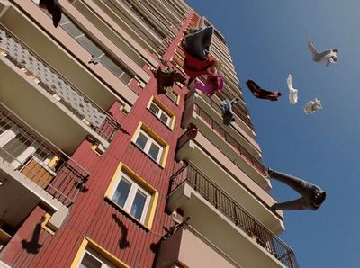 a group of birds flying around a tall building