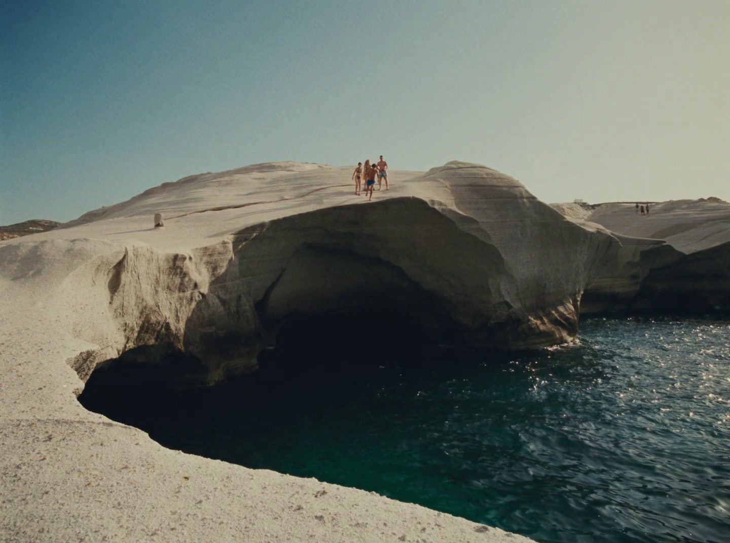 a group of people standing on top of a large rock