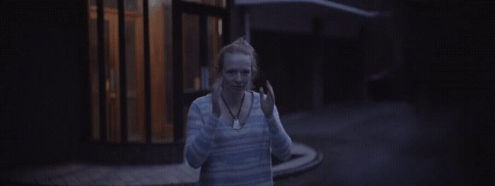 a woman walking down a street at night