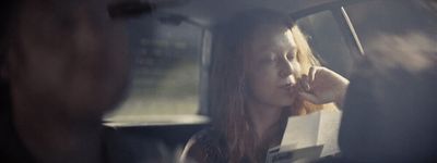 a woman sitting in a car talking on a cell phone