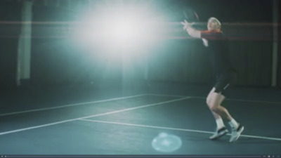 a man standing on a tennis court holding a racquet