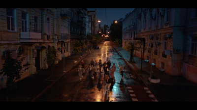 a group of people walking down a street at night