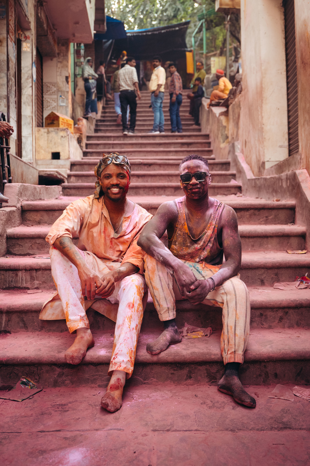 a couple of men sitting on top of a set of stairs