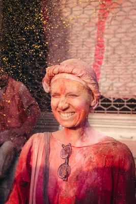 a woman covered in red and yellow powder