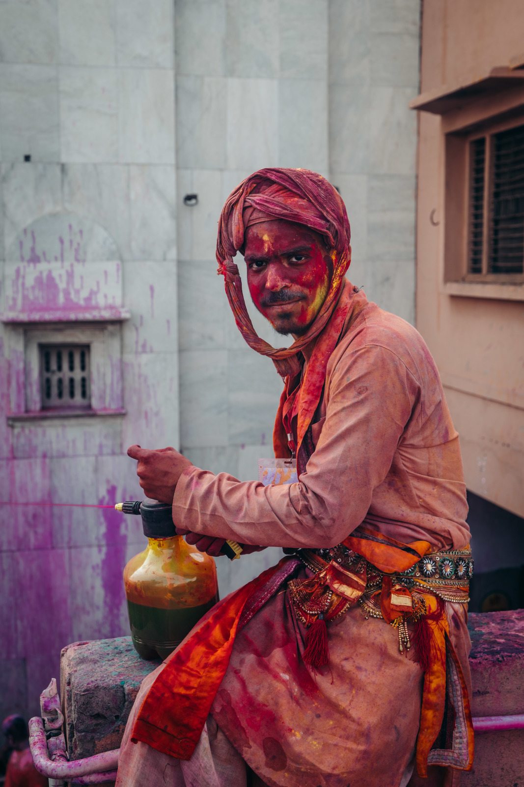 a man in a colorful outfit is holding a jug