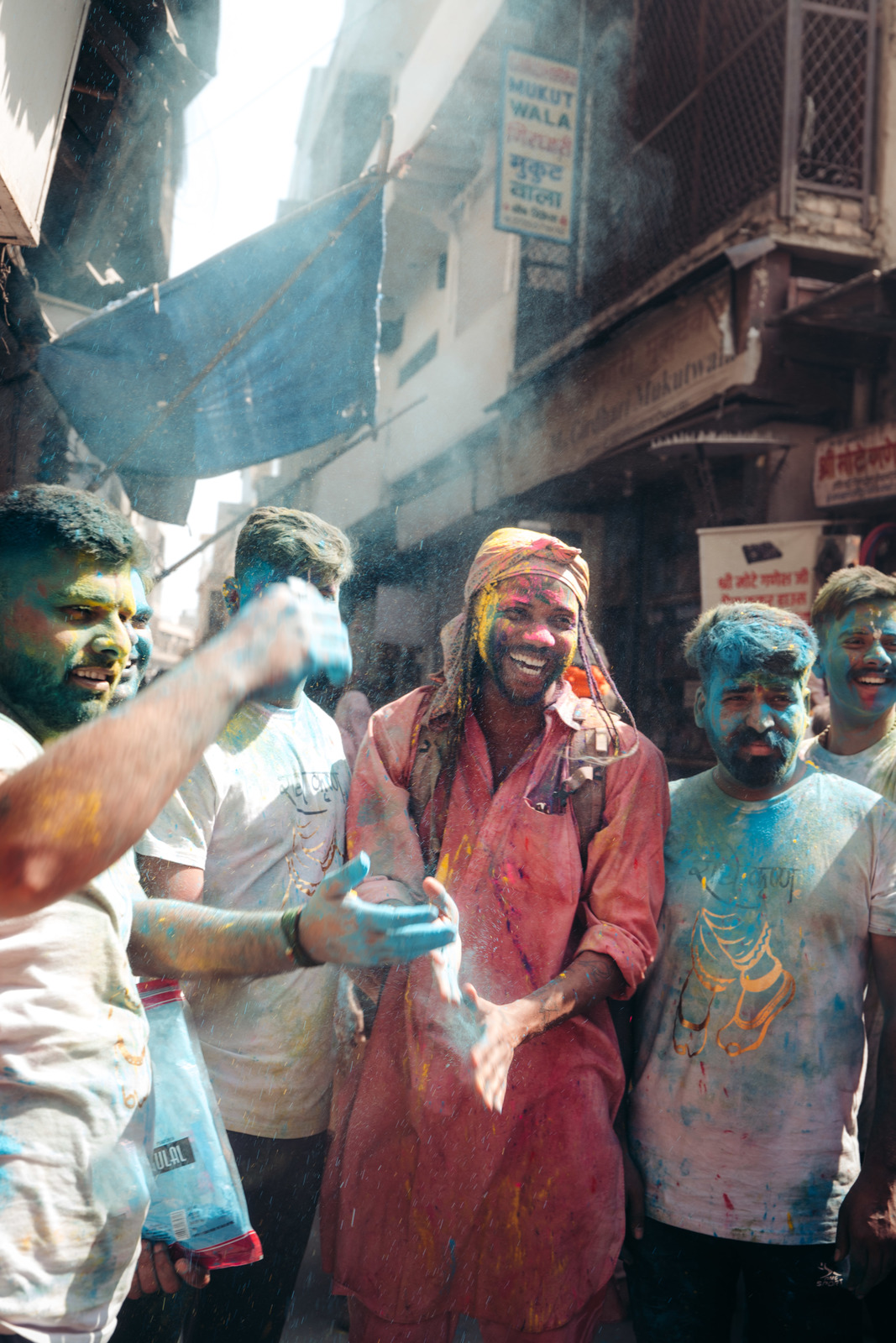 a group of people standing around each other covered in colored powder