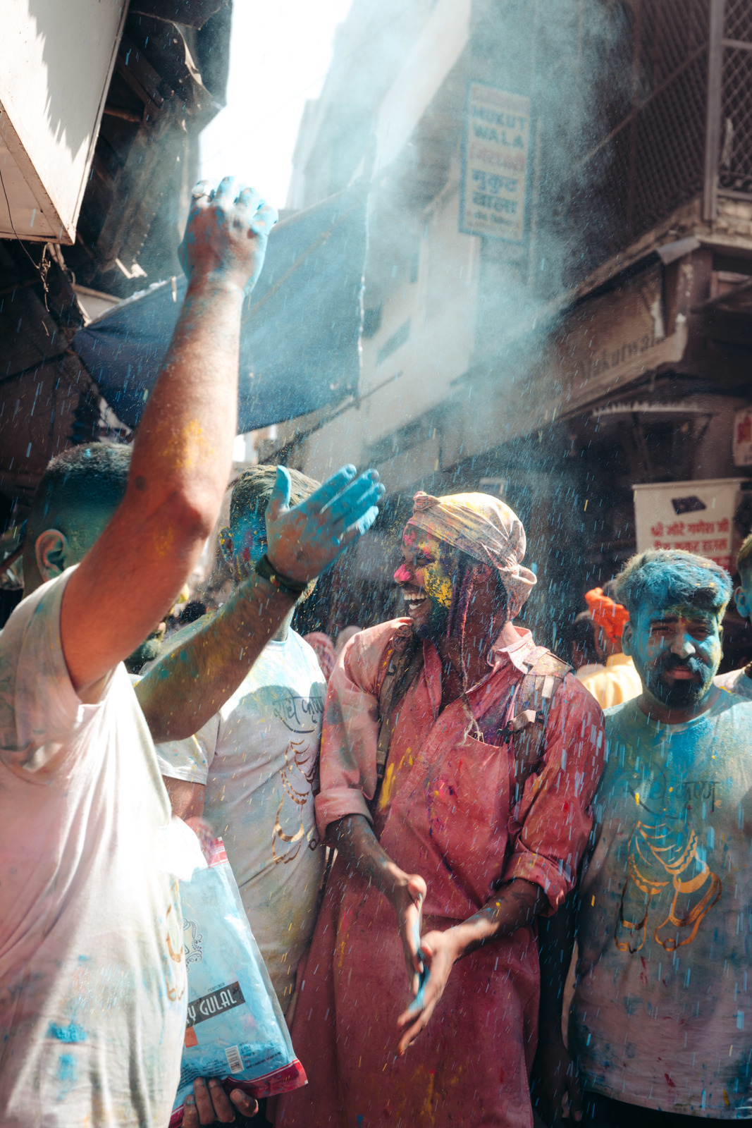 a group of people standing around each other covered in colored powder